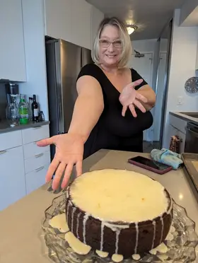 Baker decorating an allergen-safe cake in the Come Hither Kitchen workspace